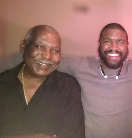 Two men are enjoying a joyful moment together, showing their affection and camaraderie at night.