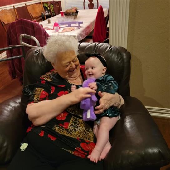 Grandmother shares a delightful moment with her smiling baby as they play together.