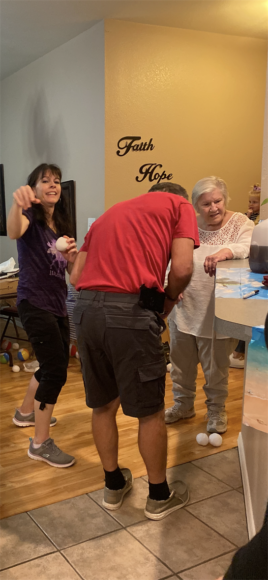 Friends engage in laughter and playful activities in a cozy living room setting.