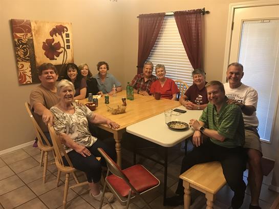 A group of friends enjoys a relaxed dinner together around a table at home.