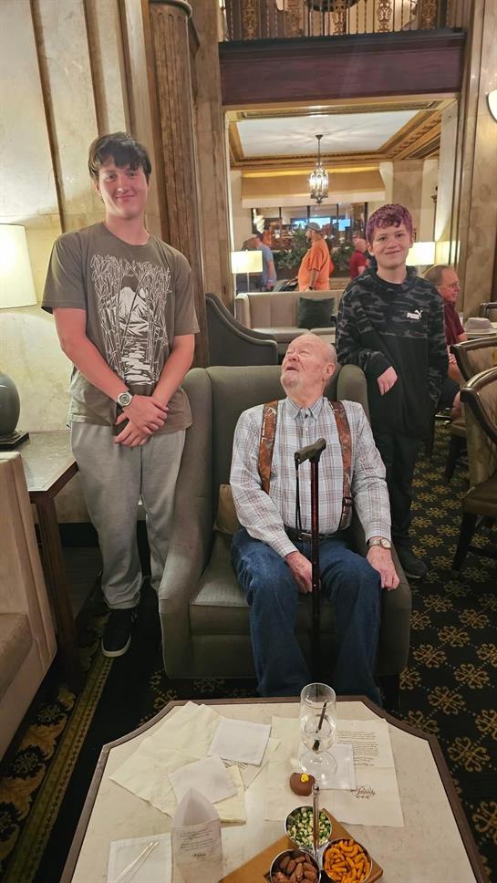 Three family members interact in an elegant lounge, showcasing a moment of togetherness and joy.