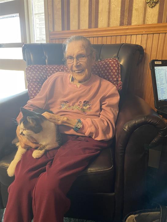 An old woman sitting in a chair with a cat
