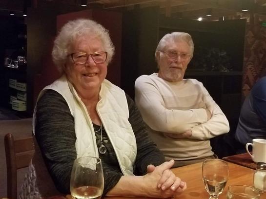 Seniors share laughter and stories while dining at a warm, inviting restaurant setting.
