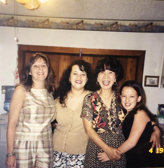 Four women pose together in a cozy living room, radiating happiness and connection.