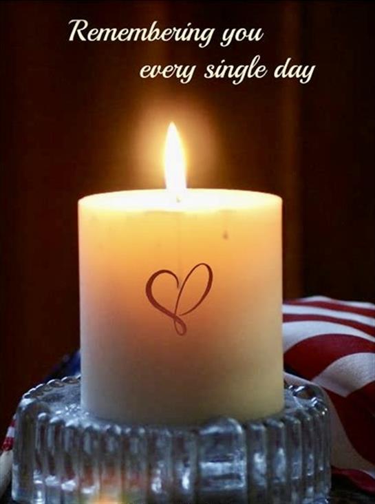 A lit candle with a heart design shines brightly in a peaceful atmosphere, signifying remembrance.