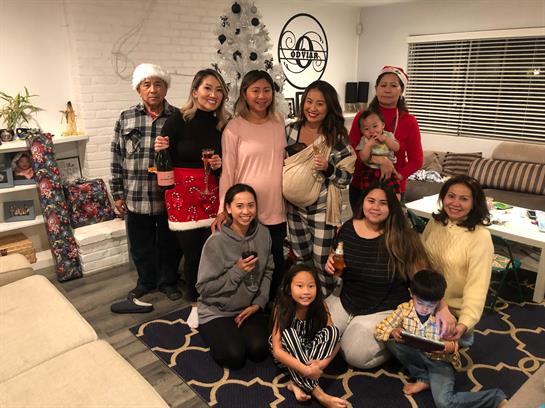A large group of family members poses in a festive living room, joyfully celebrating together.