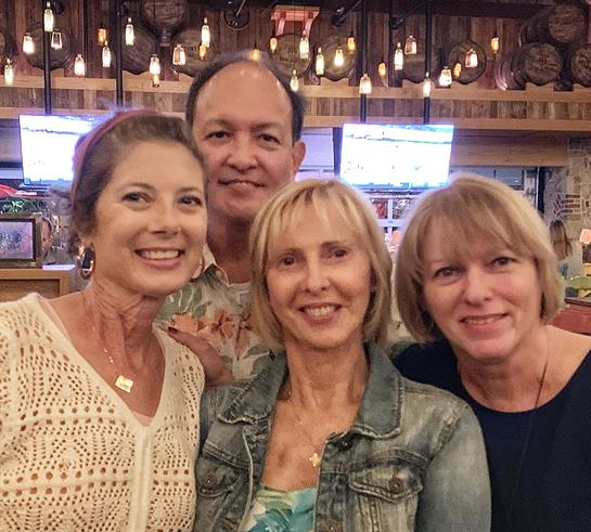 Four friends are gathered at a restaurant, sharing laughter and enjoying their time together.