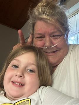 A woman and a young girl are happily posing together, enjoying a cheerful moment at home.