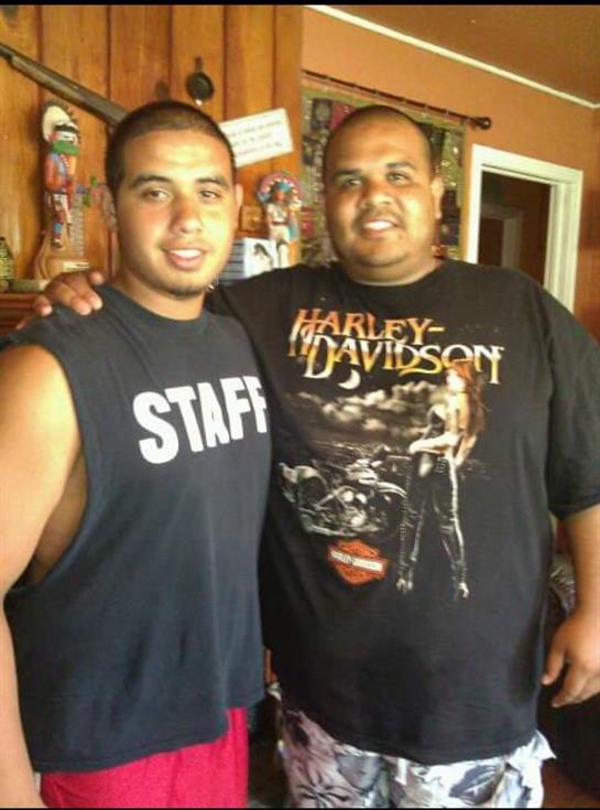 Friends smile and stand side by side in a welcoming, decorated indoor space.