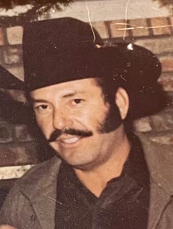 A man with a mustache and a cowboy hat