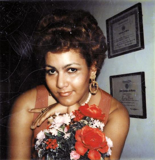 A young woman holds a vibrant bouquet indoors, showcasing her beauty and charm.