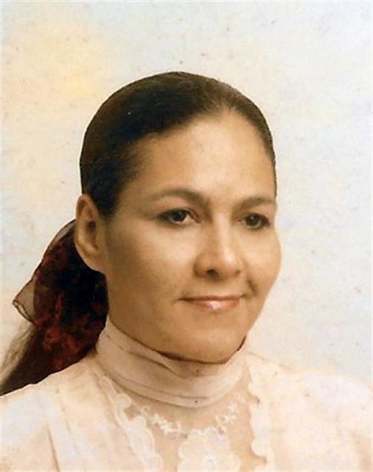 A woman with long hair and a light blouse gazes softly, projecting confidence and grace.