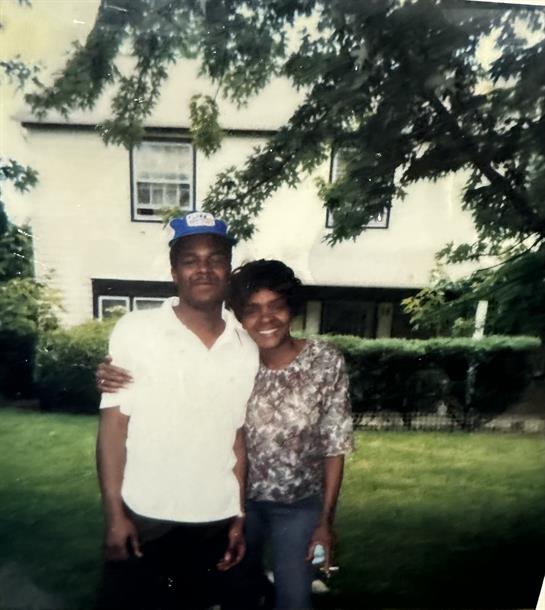 A man and woman standing in front of a house