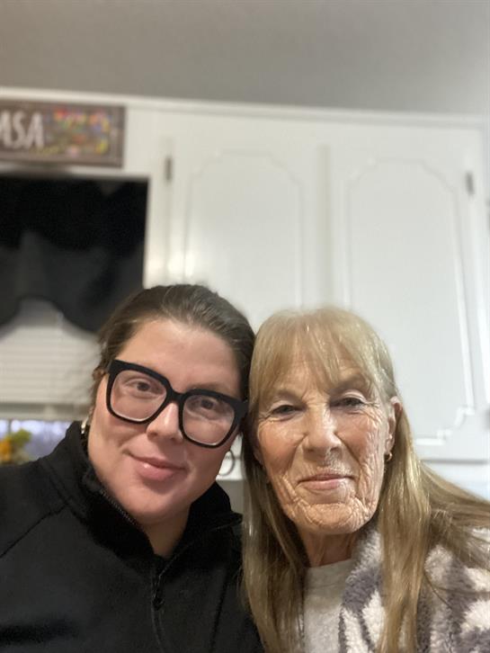 Two women enjoy a heartwarming moment together in a welcoming kitchen filled with warmth.