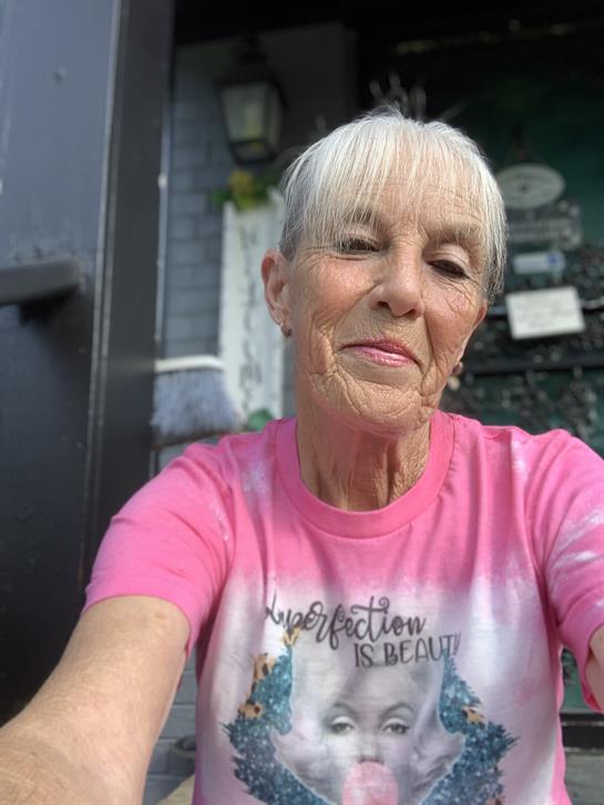 Senior outdoors in a pink shirt, smiling, enjoying a relaxed afternoon vibe.