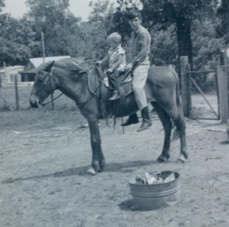A man and child riding a horse
