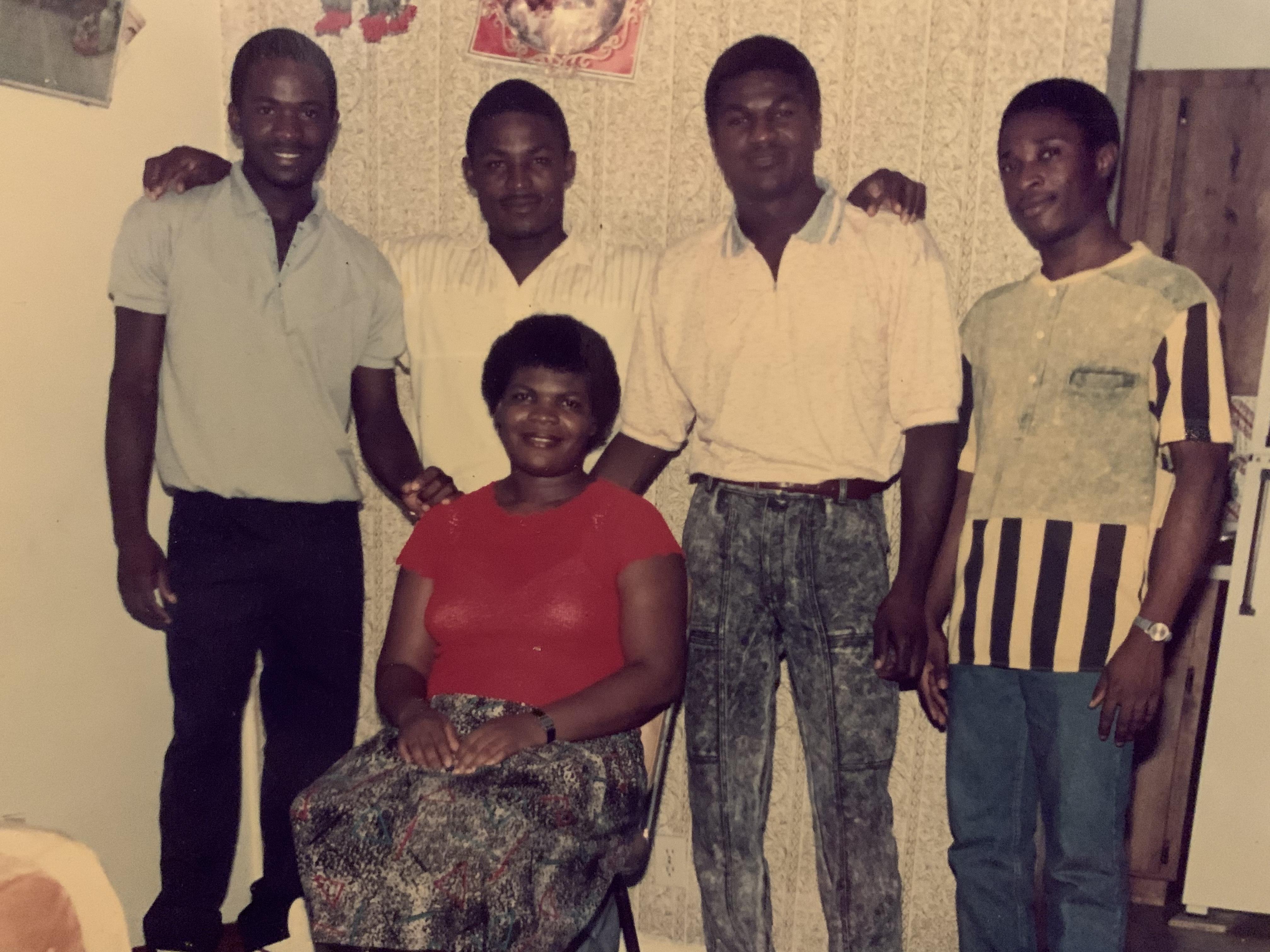 Five friends pose together, sharing laughter and smiles in a cozy interior during the 1990s.