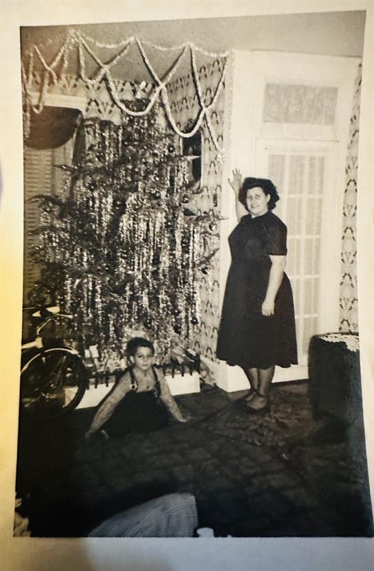 A woman and child in front of a christmas tree