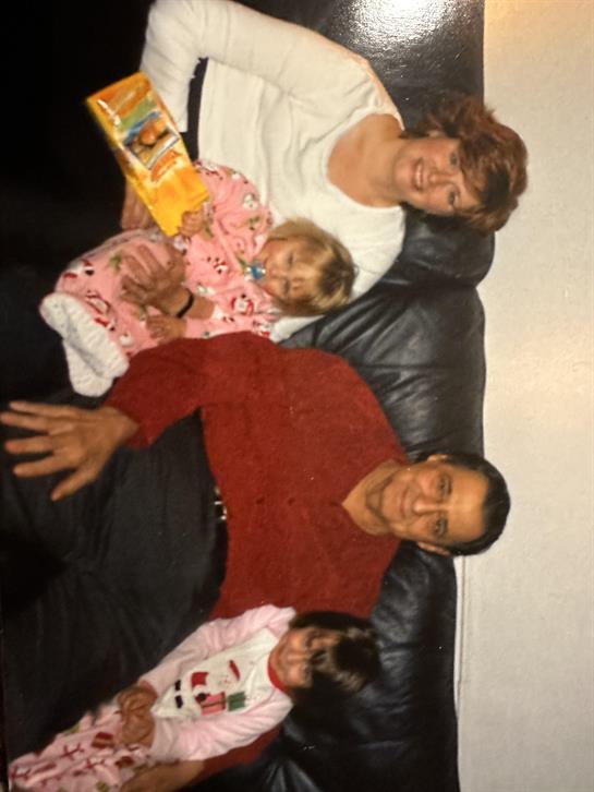 A man and woman sitting on a couch with a baby