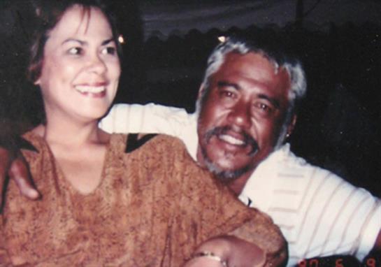 Two friends enjoy a joyful moment together, smiling and celebrating in an outdoor gathering.