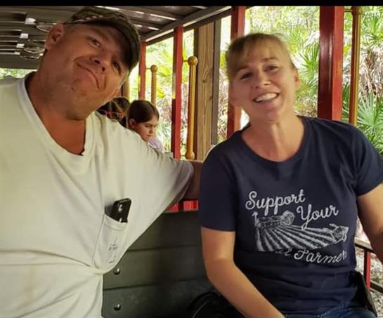 Two friends share a joyful moment on a train ride, surrounded by nature and laughter.