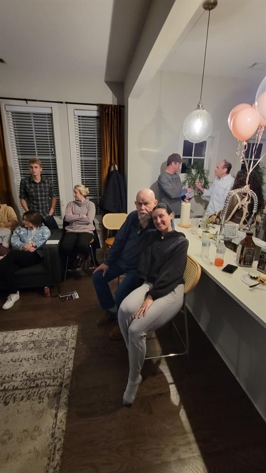 People are enjoying each other's company at a warm gathering in a comfortable living space.