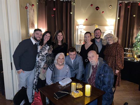 Friends and family enjoy a warm evening together at a cafe, sharing laughter and smiles.