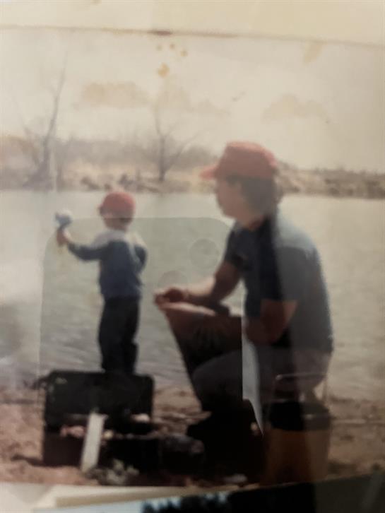 A man and child standing on a beach