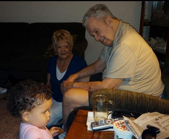 Grandparents bond with their grandchild in a cozy living room during family time.