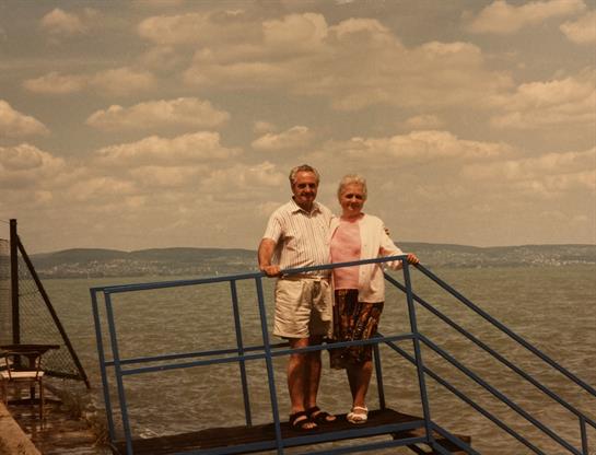 A man and woman standing on a metal railing