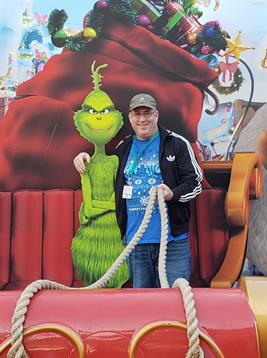 A man standing next to a large green character