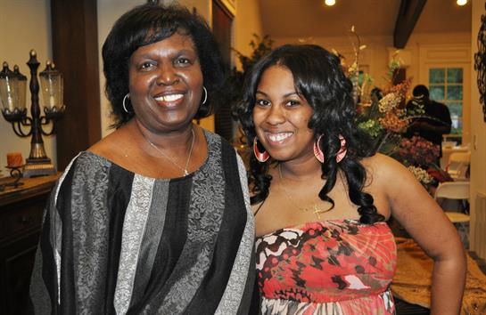 Two women are smiling and enjoying each other's company during a cheerful gathering.