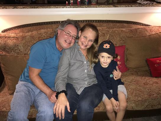 Family gathers on a sofa for a joyous moment filled with smiles and togetherness in a home setting.