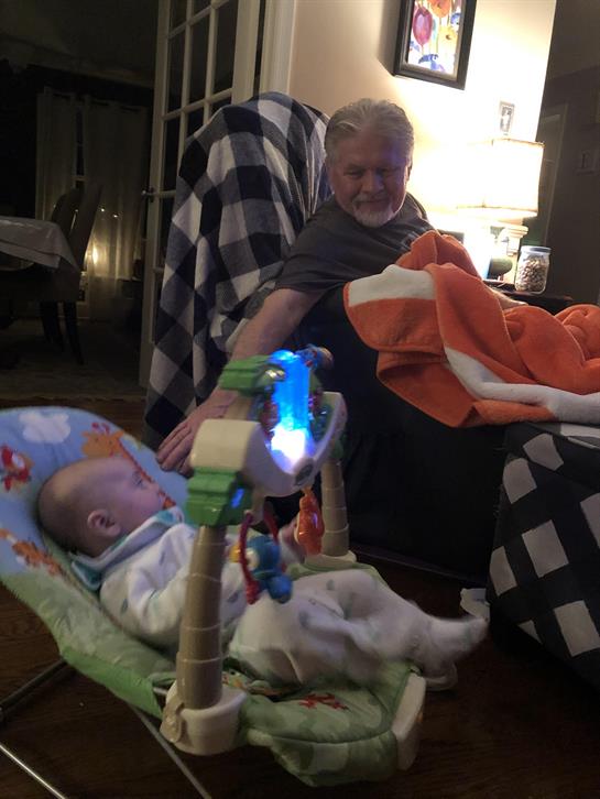 A man sitting in a chair with a baby