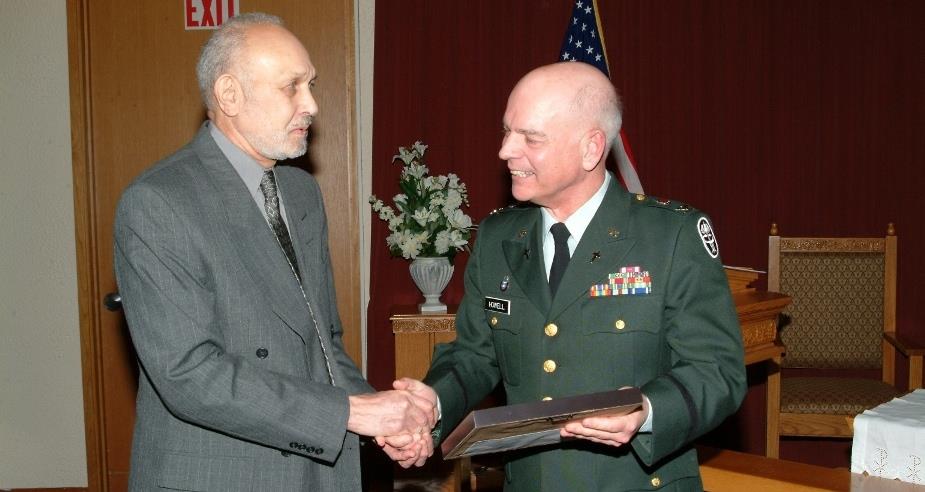 A man in a military uniform shaking hands with another man