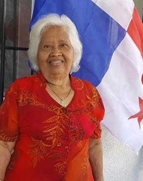 A woman standing in front of a flag