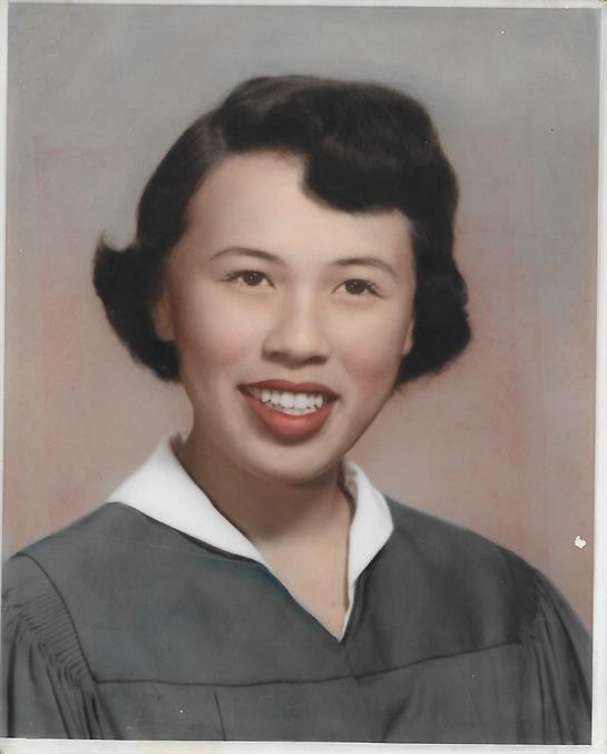 A happy graduate wearing a gown and a white collar, displaying pride in academic success.