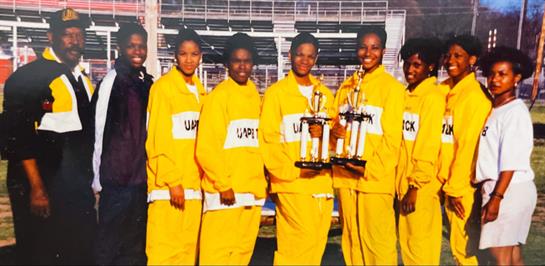 Young athletes proudly hold trophies after winning a cheerleading competition outdoors.