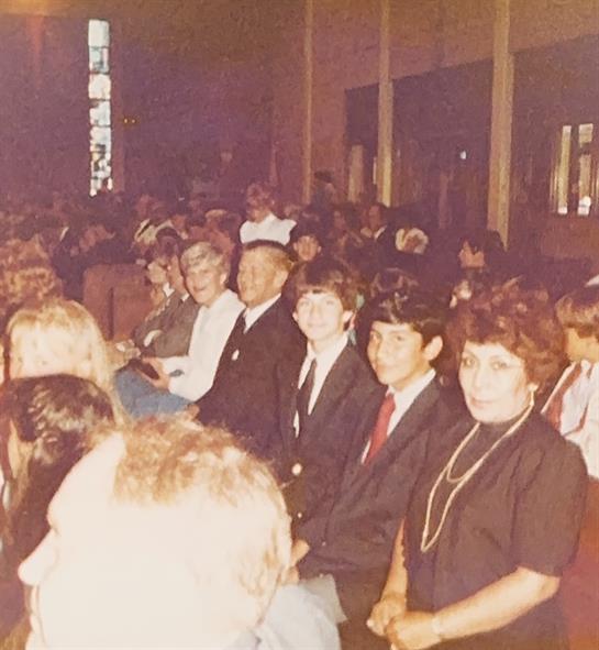 Attendees gather in a large hall for a significant community event with lively interaction.