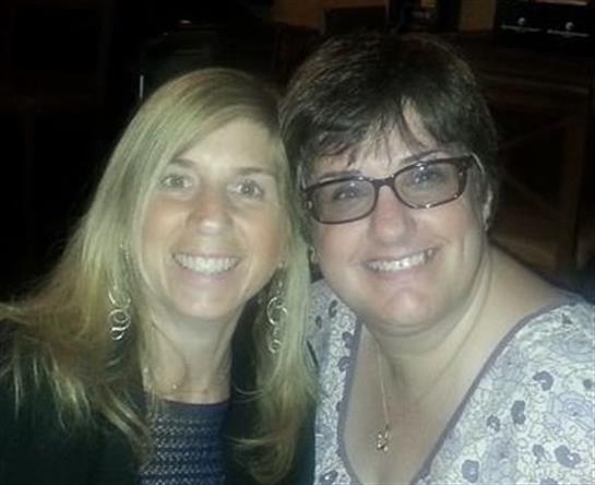 Two friends enjoy each other's company while dining at a cozy restaurant during the evening.