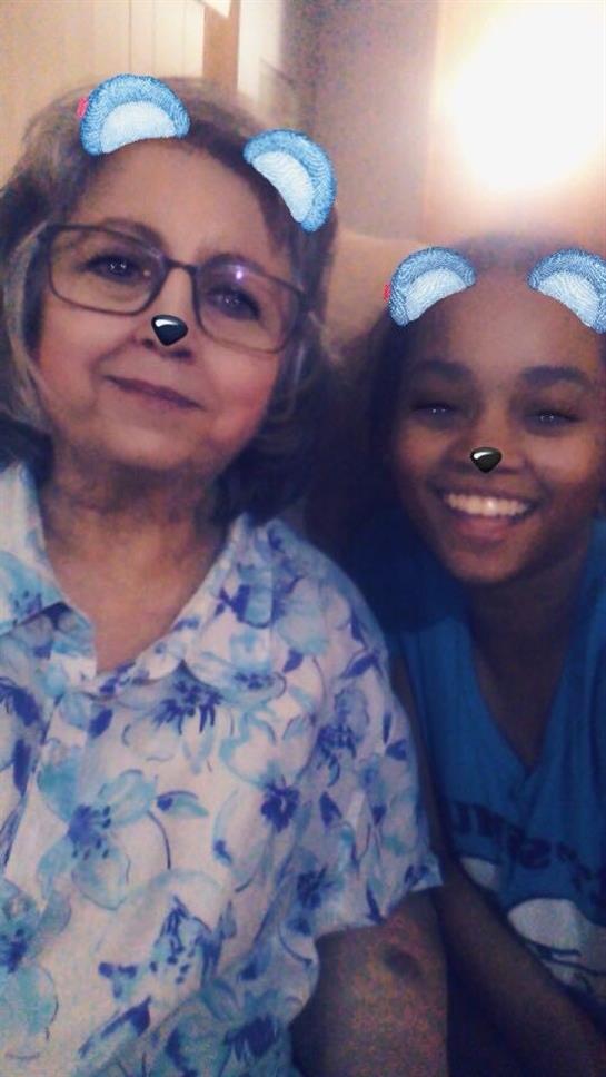 Two people share a joyful moment using playful filters while relaxing at home together.