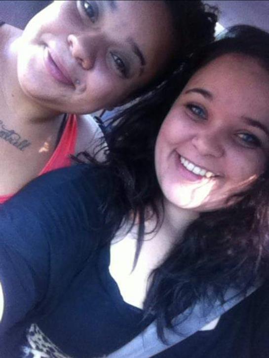 Two women enjoy a cheerful moment together inside a car, beaming with happiness.