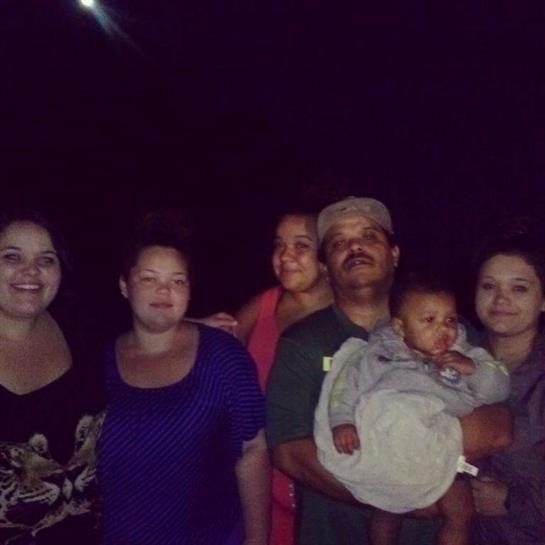A group of six people stands together under soft night lighting, enjoying their time.