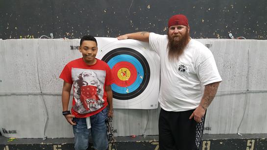 Two men standing next to a target