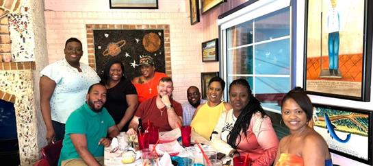 A lively group gathers at a table adorned with delicious dishes, sharing laughter and joy.