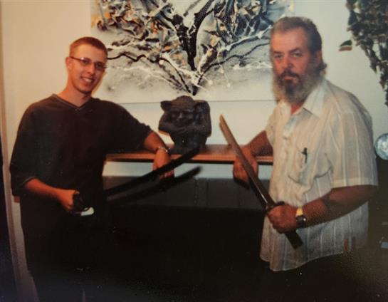 A man holding swords and standing next to another man