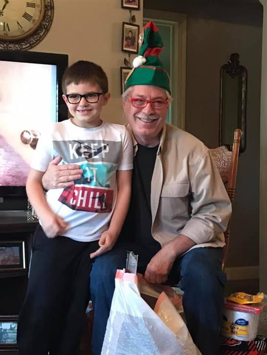 Two generations enjoy a joyful moment together, dressed festively, surrounded by holiday gifts.