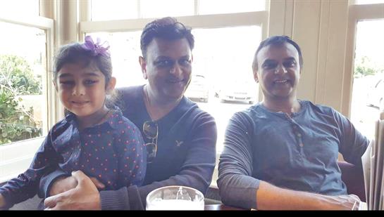 A joyful family shares moments in a warm cafe, enjoying their time together.