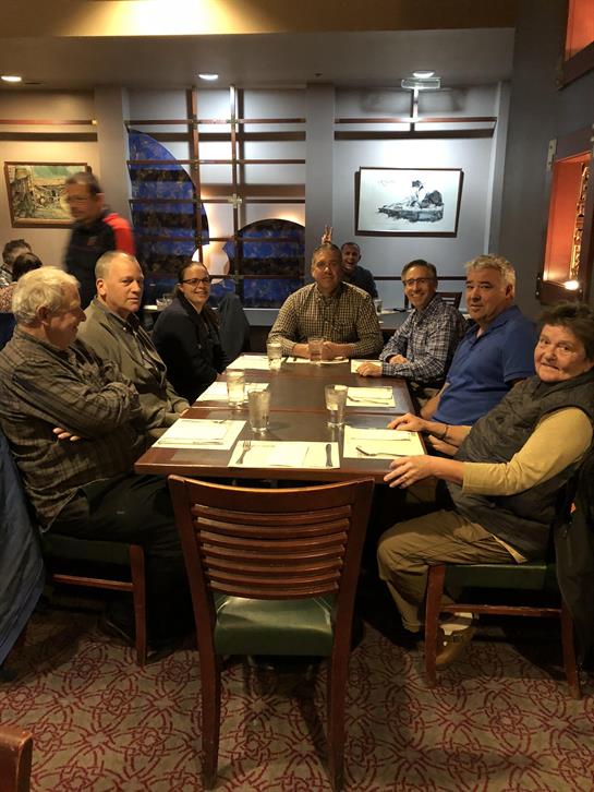 A group of friends sits around a table, engaged in conversation and sharing laughter during dinner.