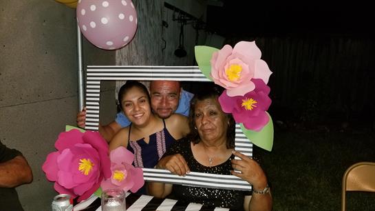 Family gathers at night posing joyfully in a decorated frame, smiling and enjoying the moment.